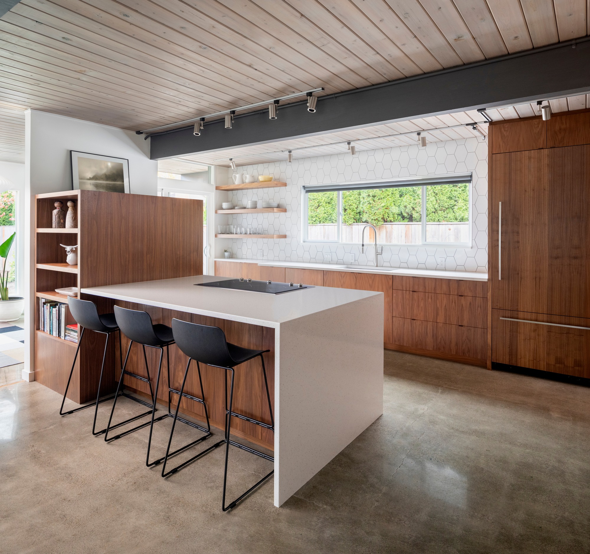Modern kitchen interior after detailed construction cleaning in Naples, FL, with wood cabinetry, white countertops, and open shelving.